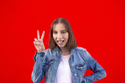 Portrait of mid adult woman against red background