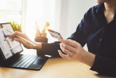 Midsection of man using laptop on table