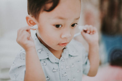 Close-up of cute boy holding stethoscope at home