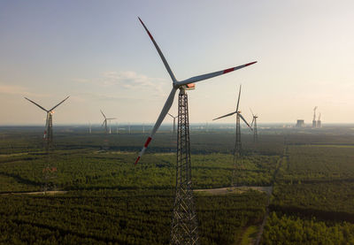 Windmills on field against sky