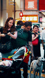 People looking at young woman on street in city