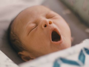Close-up of cute baby yawning at h