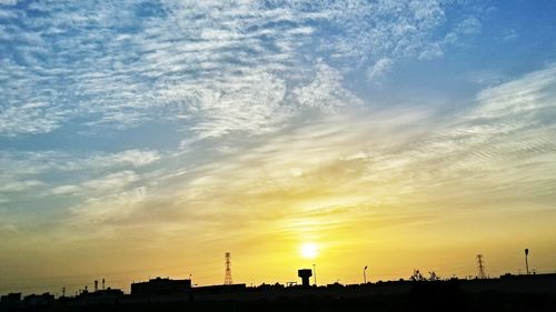 Silhouette of city against sky during sunset