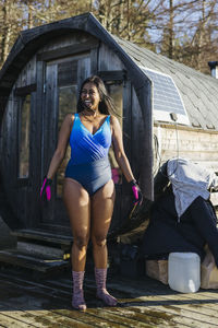 Woman preparing for swim, sauna in background