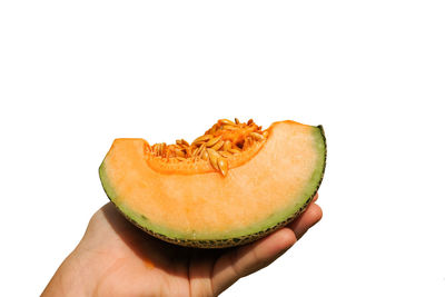Close-up of hand holding apple against white background