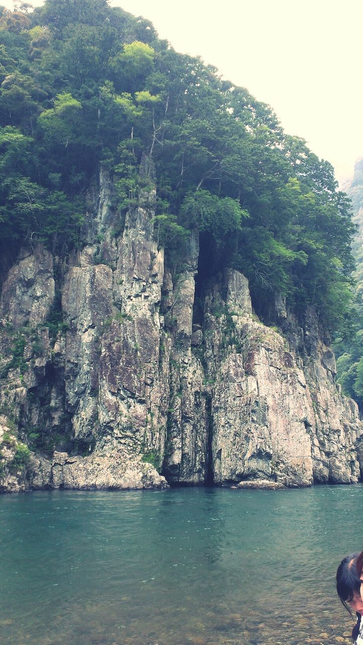 water, rock - object, leisure activity, lifestyles, tree, rock formation, men, nature, beauty in nature, cliff, scenics, tranquility, person, vacations, sea, tranquil scene, day, mountain