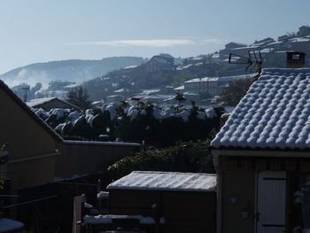 Houses and buildings against sky during winter