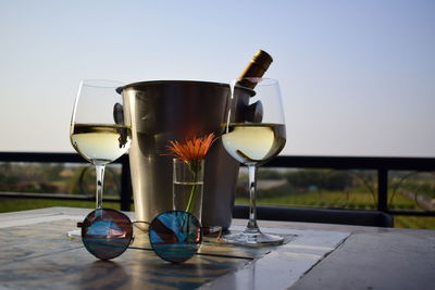 Close-up of wine glasses on table against clear sky