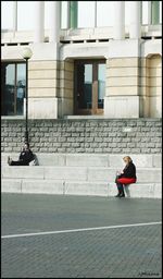 Woman standing on footpath in city