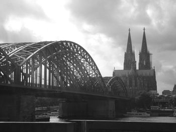 Arch bridge over river against buildings in city