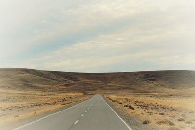 Road passing through landscape against sky