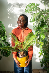 Young woman standing against plants