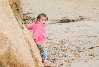 Side view of boy standing on rock