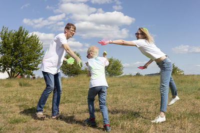 Caucasian parent and child play with colorful dye at birthday party or celebrating holi color