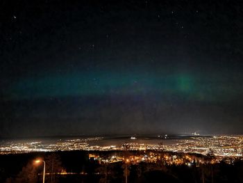 Illuminated cityscape against sky at night