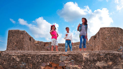 Low angle view of women standing against sky