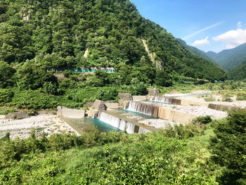 Scenic view of dam and trees on mountain