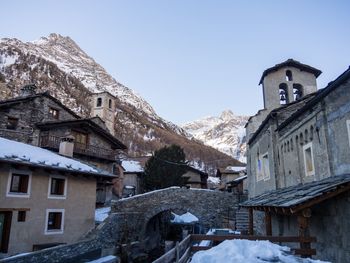 Houses on snowcapped mountains against clear sky