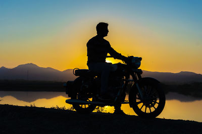 Biker on bike near salt lake during sunset