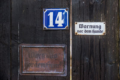 Close-up of arrow sign on wooden door