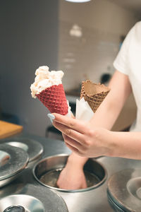 Seller selling couple scoops of ice cream in a candy shop by a street