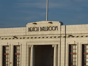 Low angle view of text on building against sky