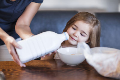 Mother preparing breakfast for her daughter