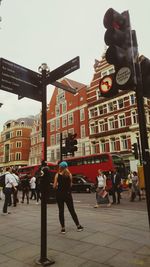 People walking on street in city against sky