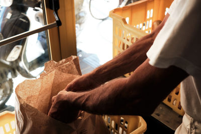 Cropped hands of man holding bread in a bakery