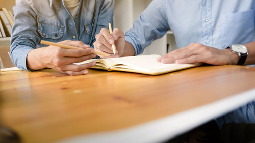 Close-up of couple holding book