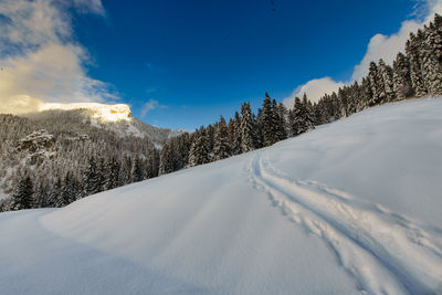 Snow covered landscape against sky