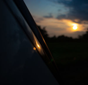 Close-up of illuminated light against sky during sunset