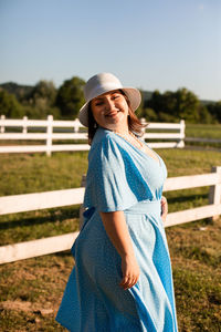 Portrait of smiling woman standing against sky