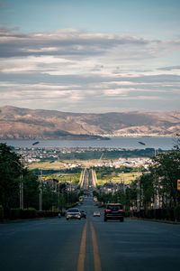 Cars on road against sky in city