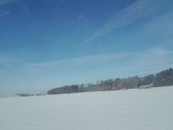 Scenic view of snow covered land against blue sky