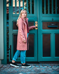 Full length of woman standing against door