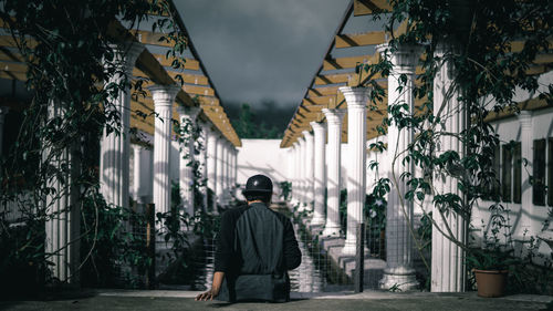 Rear view of man standing by buildings in city