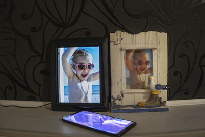 Portrait of woman with mobile phone in mirror