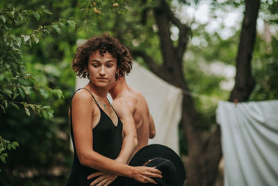 Full length of woman standing against trees