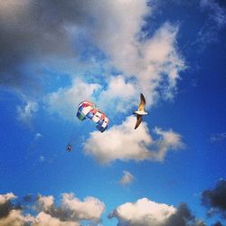 Low angle view of parachute against cloudy sky