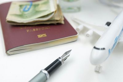 High angle view of toy airplane by fountain pen and passport on table