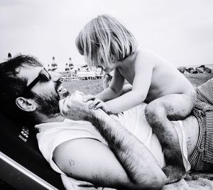 Cute girl playing with father at beach