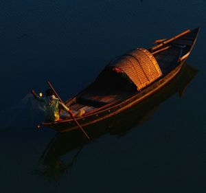 High angle view of fisherman in boat on sea during sunset