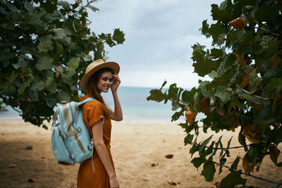 Woman standing on tree against plants