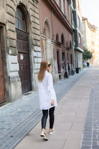 Rear view of woman walking on street in city