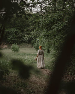 Rear view of woman walking in forest