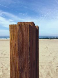 Wooden posts on beach against sky