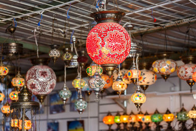 Low angle view of illuminated lanterns hanging in store
