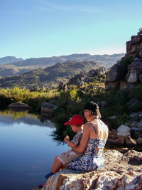 Mother and son sitting on rock formation