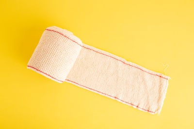 Close-up of rolled bandage over colored background